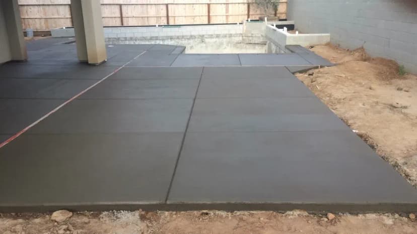 Concrete driveway in progress near residential structure