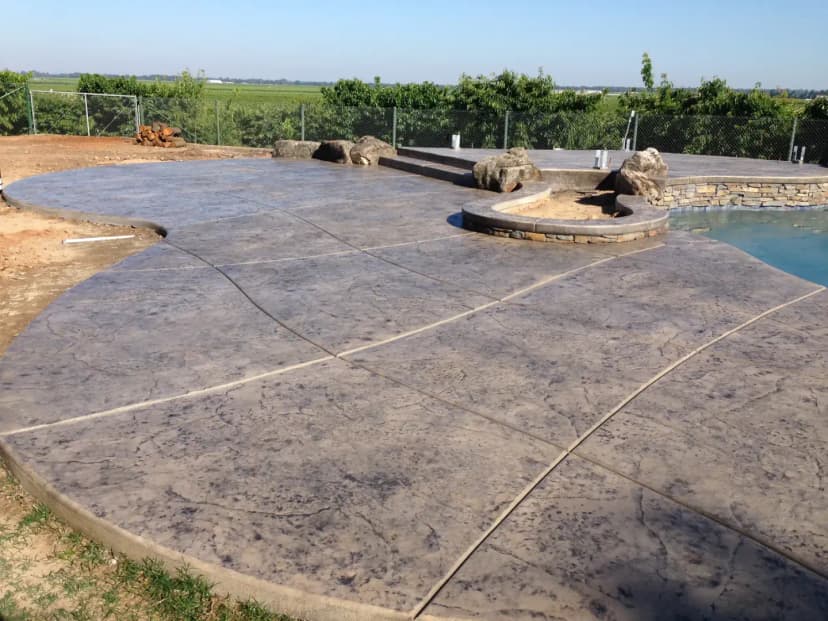 Concrete patio pad with decorative finish and rock landscaping
