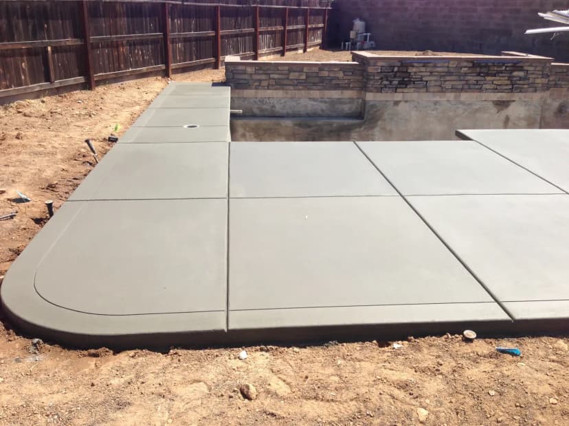 Concrete pads with retaining wall and stone veneer trim
