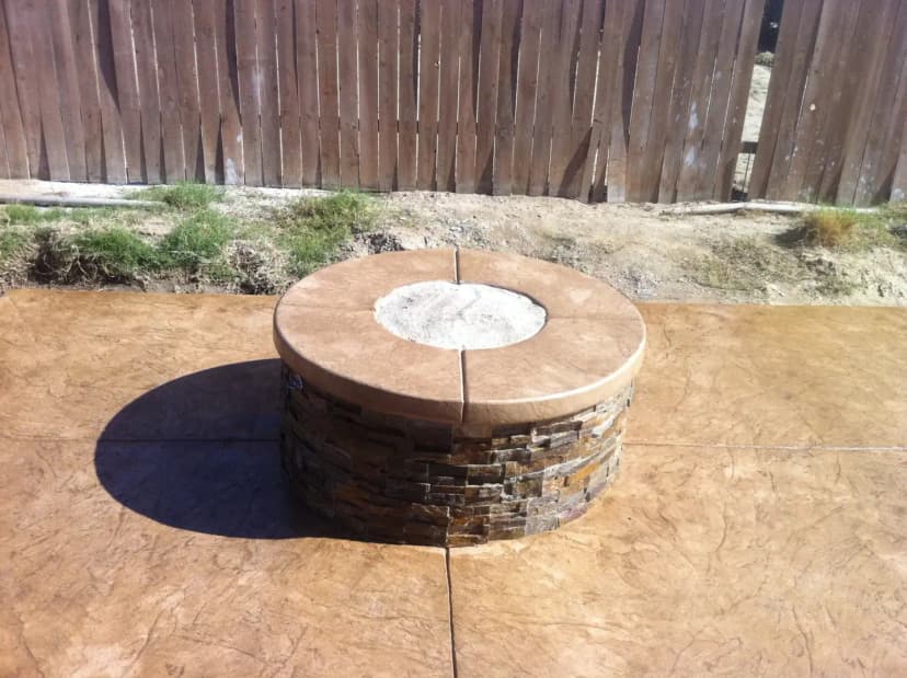 Decorative concrete patio with circular fire pit seating area