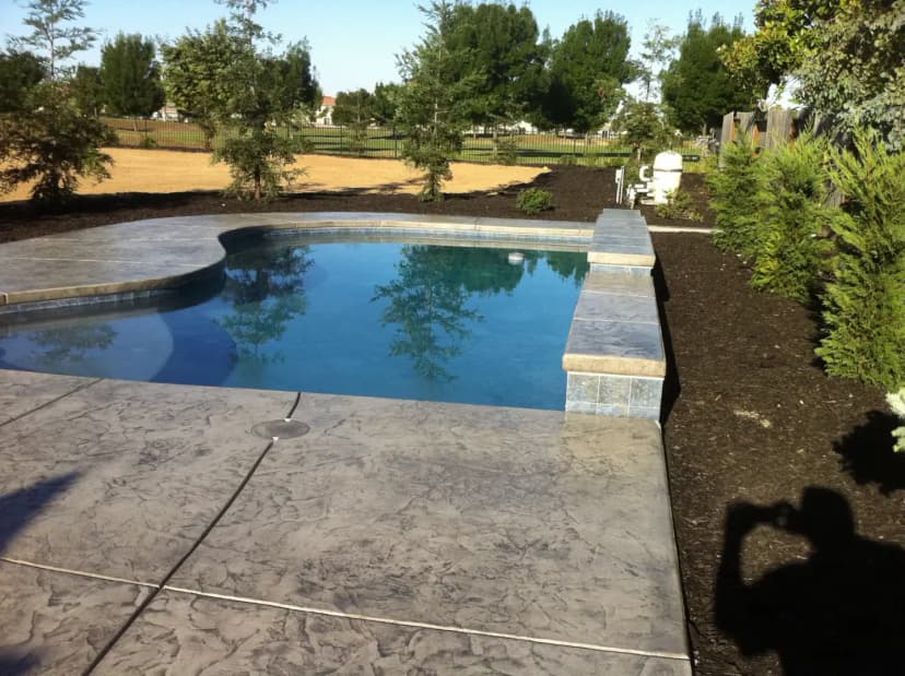 Residential pool with stone coping and decorated concrete deck