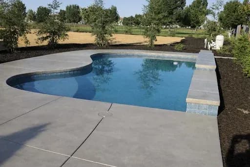 Pool with stone coping and decorated concrete deck