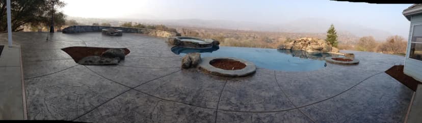 Resort pool deck with concrete patio and multiple fire features