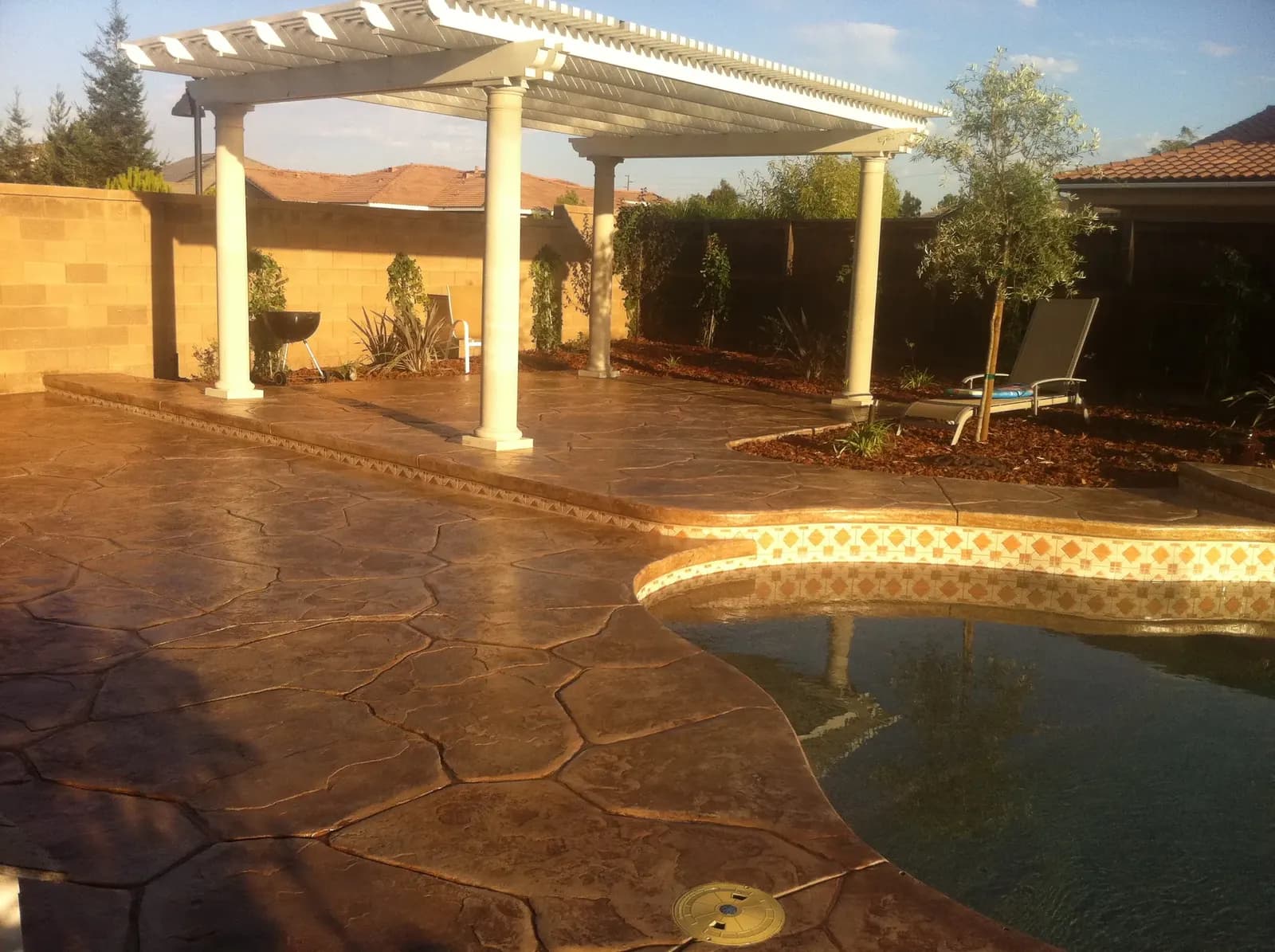 Covered concrete patio with pergola and outdoor seating