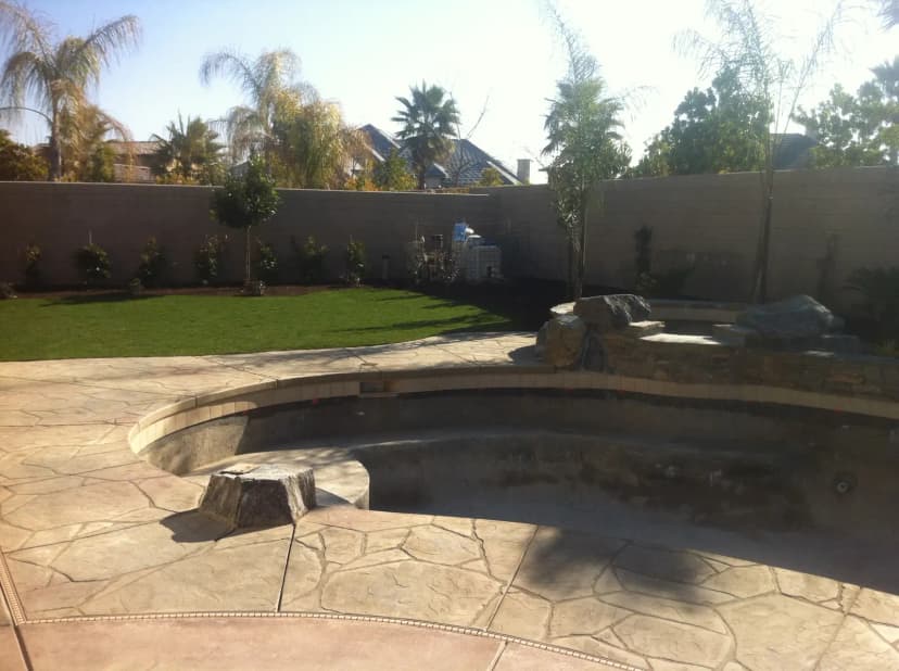 Decorative concrete border around pool with colored patterns