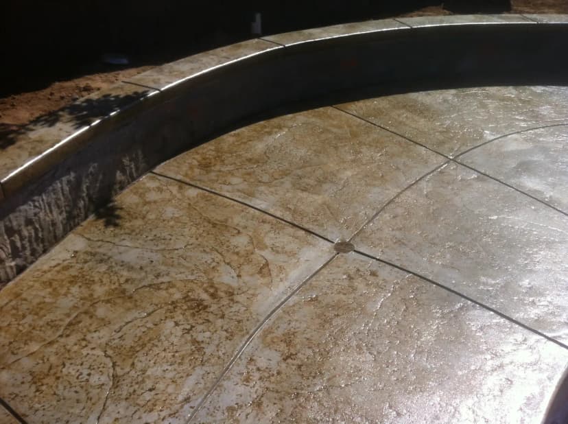 Concrete patio with circular fire pit and stone accents
