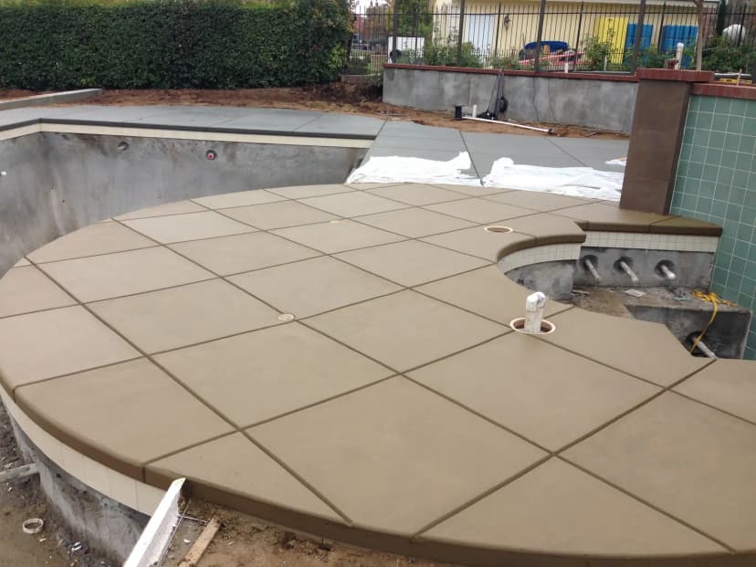 Backyard patio concrete pour in progress with tools