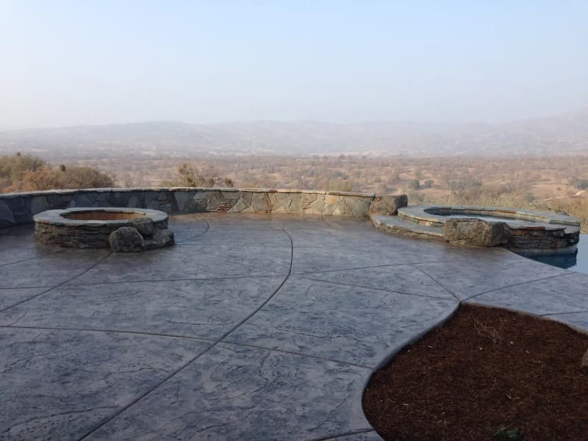Concrete patio with circular fire pits and mountain views
