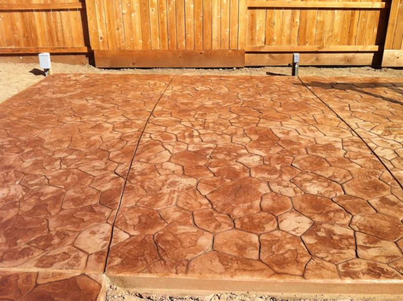 Rust colored stamped concrete in backyard