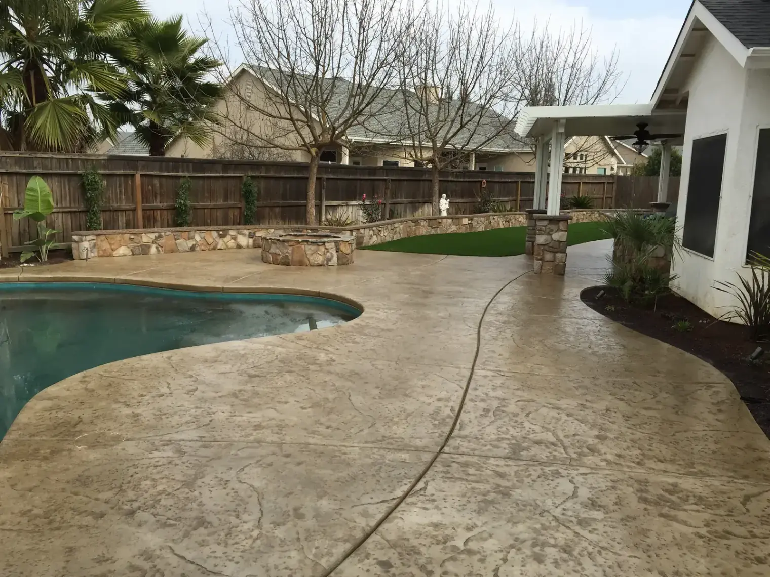 Stamped concrete backyard patio with plants