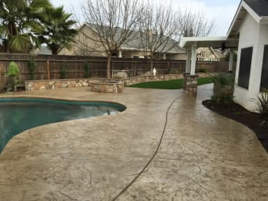 Stamped concrete backyard patio with plants