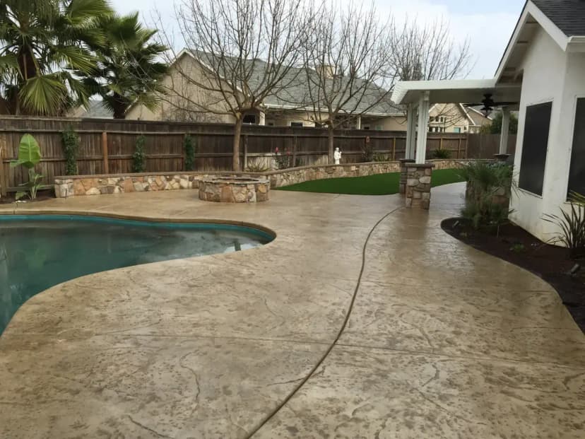 Stamped concrete backyard patio with plants