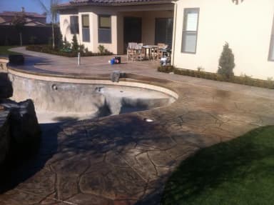 Backyard patio with decorative concrete and spa