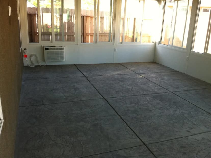 Textured concrete floor with decorative score pattern inside.