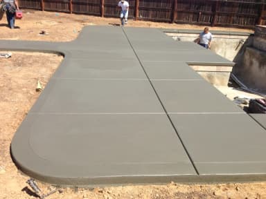Large backyard stamped concrete patio with retaining walls.