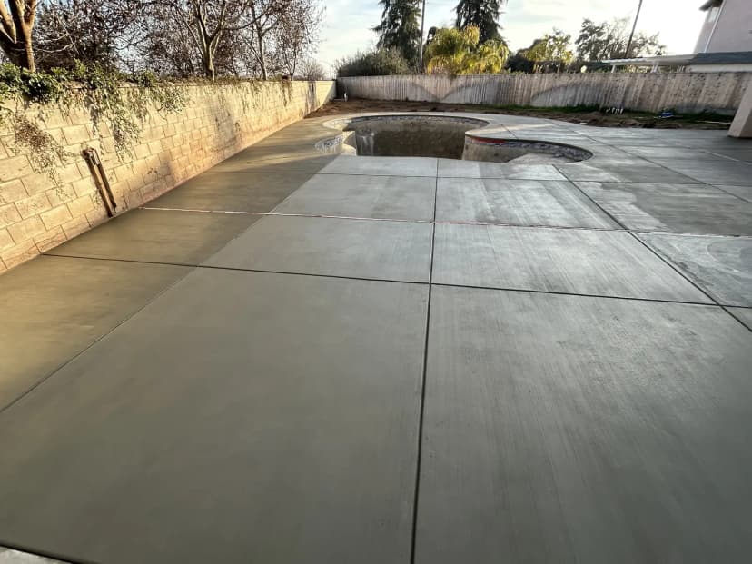 Concrete surface with wood-grain texture and cut lines.