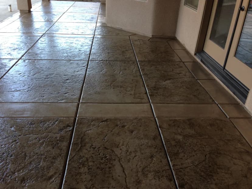Smooth concrete patio with decorative scored pattern lines.