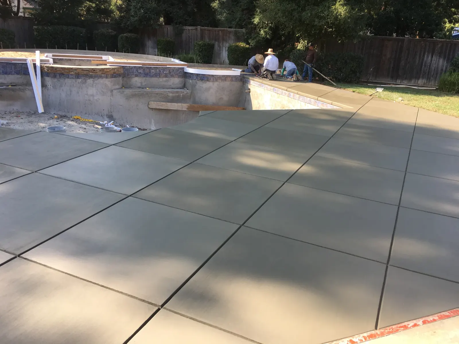 Covered patio with finished concrete floor and pillars.