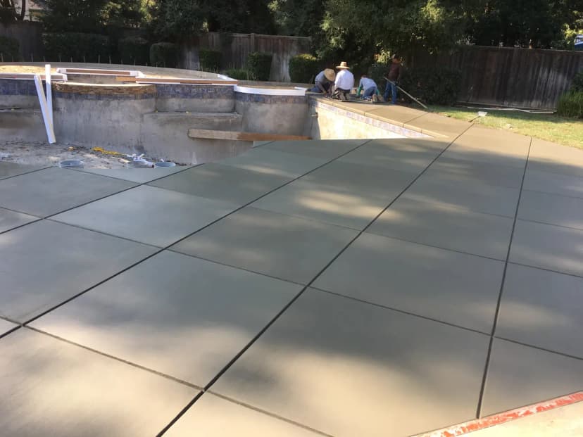Covered patio with finished concrete floor and pillars.