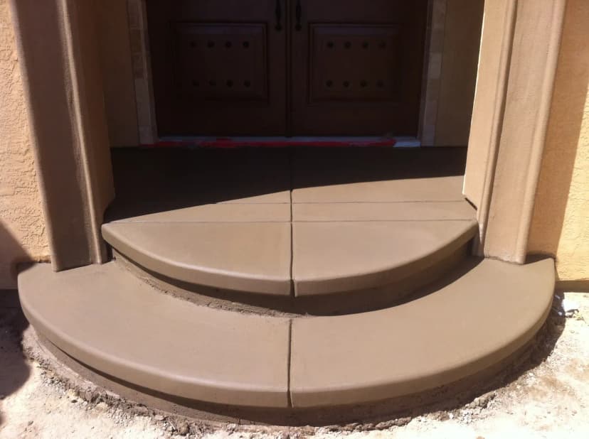 Curved concrete entrance step with smooth finish.