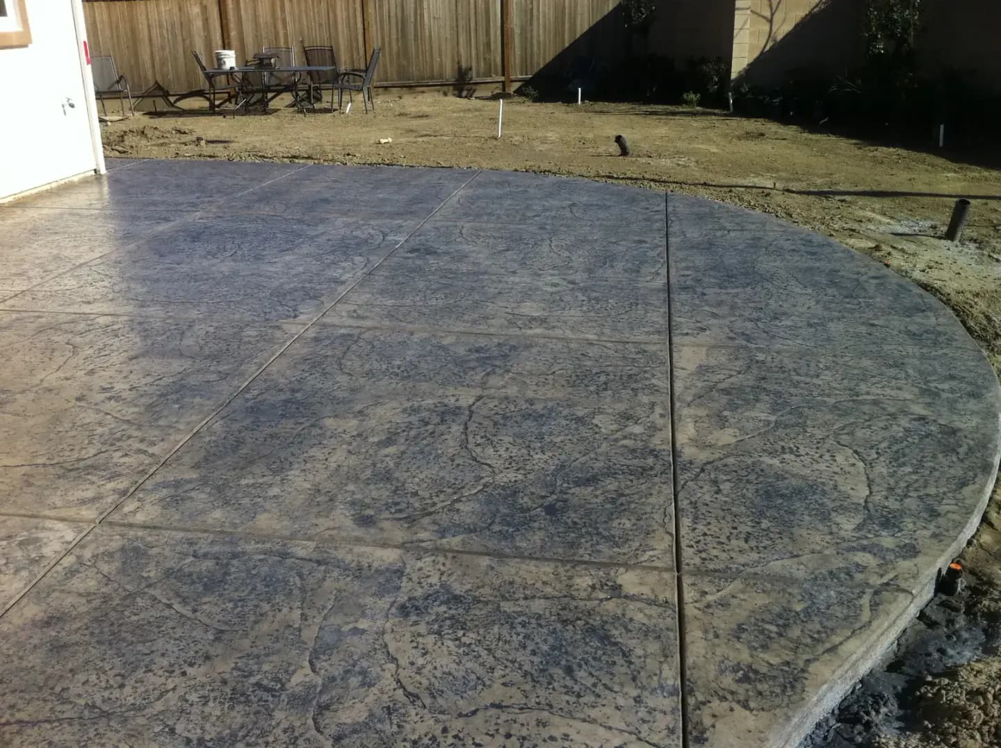 Backyard patio with stamped concrete texture.