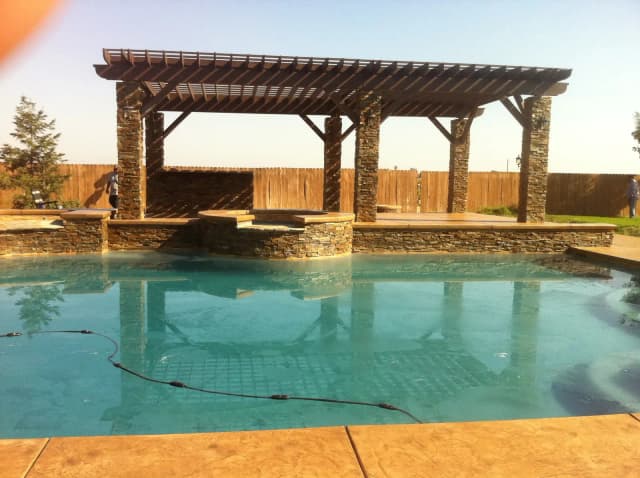 Pool with concrete surround and pergola