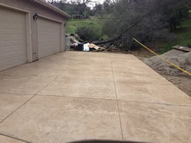 Fresh concrete driveway next to garage doors