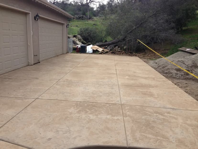 Fresh concrete driveway next to garage doors