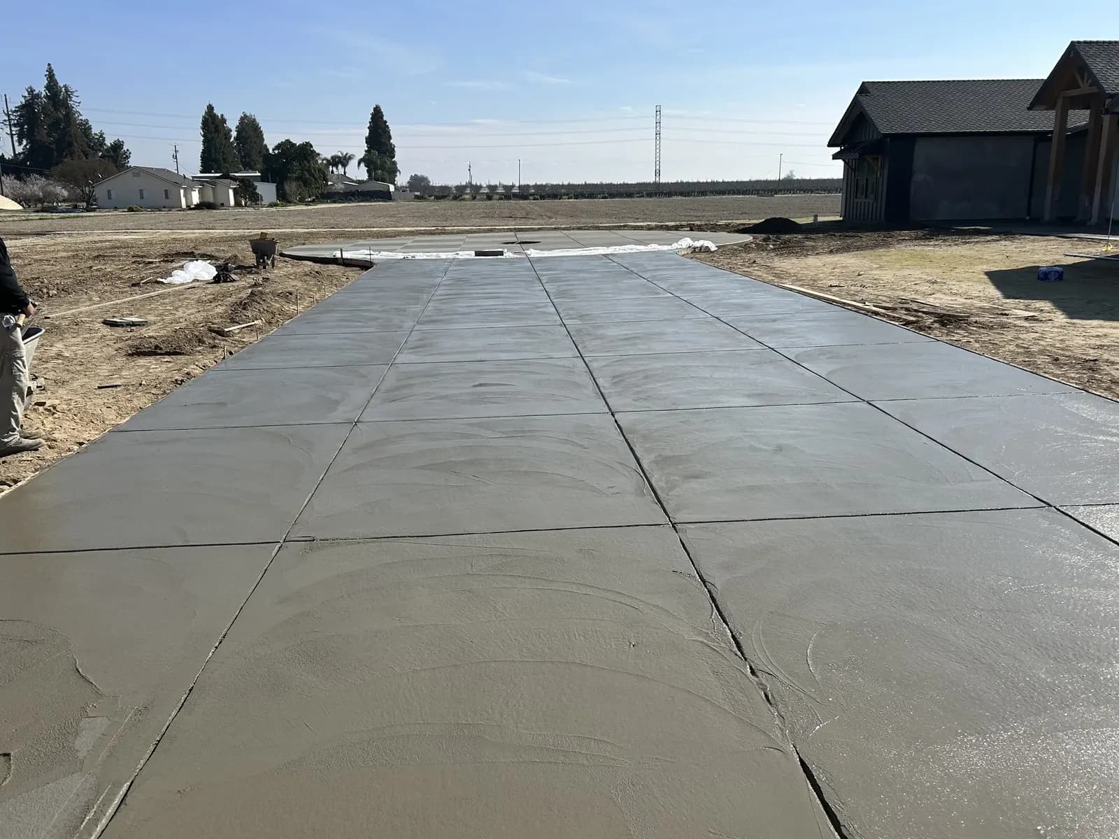 Fresh concrete driveway with scoring leading to house