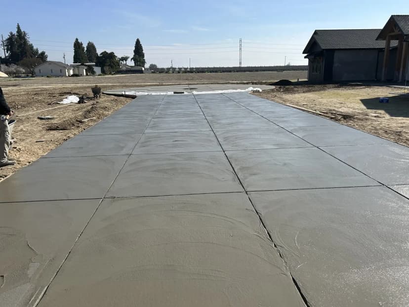 Fresh concrete driveway with scoring leading to house