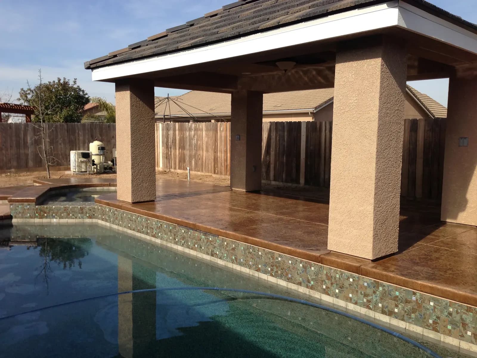 Pool deck with covered pergola and decorative concrete