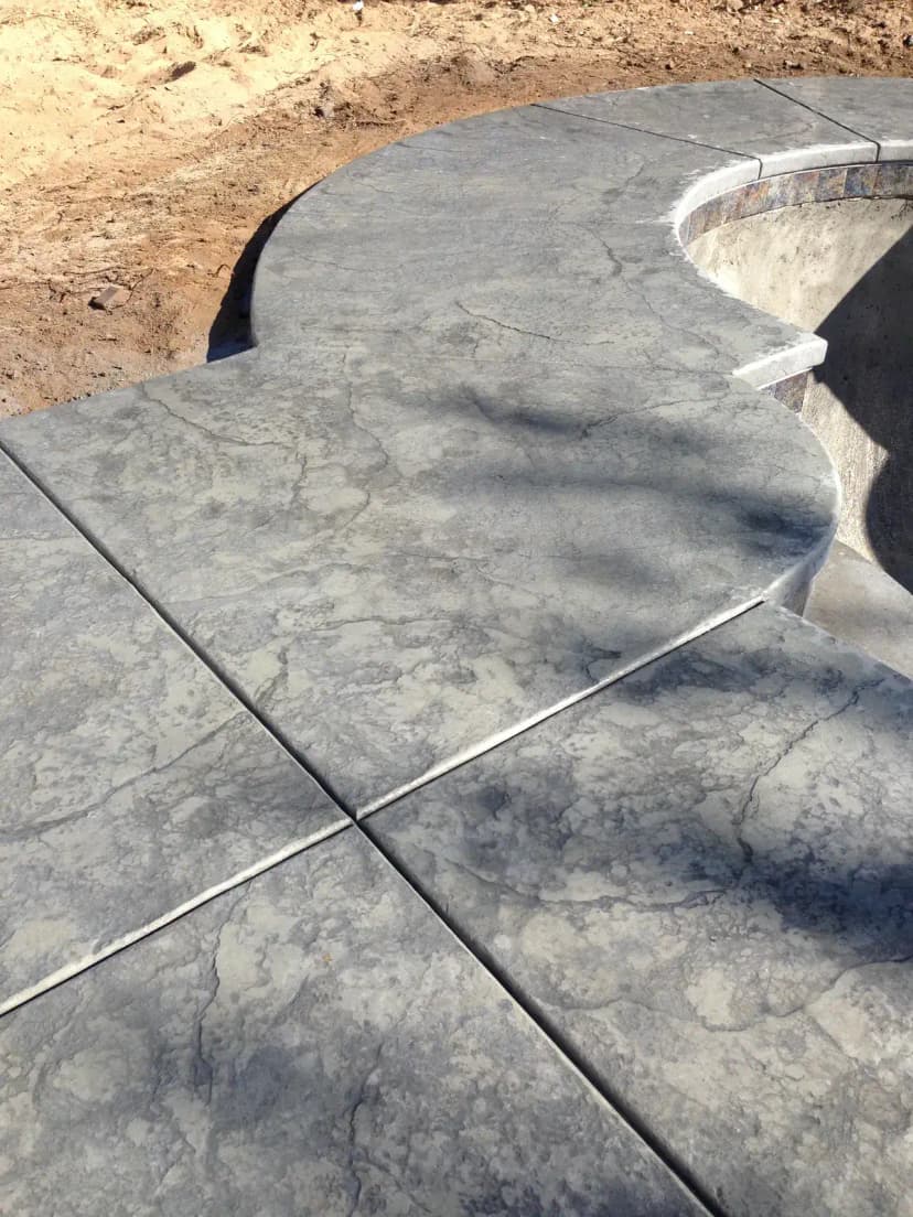 Concrete flatwork pad with saw-cut lines